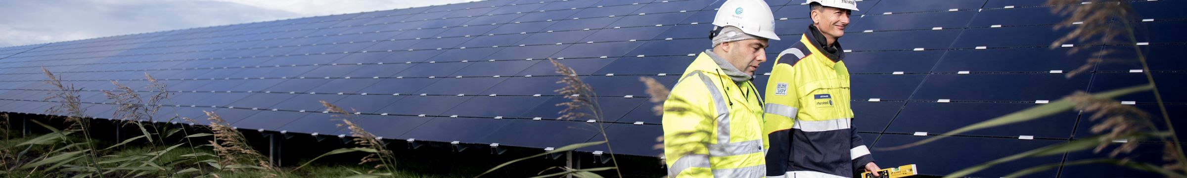 Zwei Mitarbeiter laufen im Solarpark Lange Runde herum