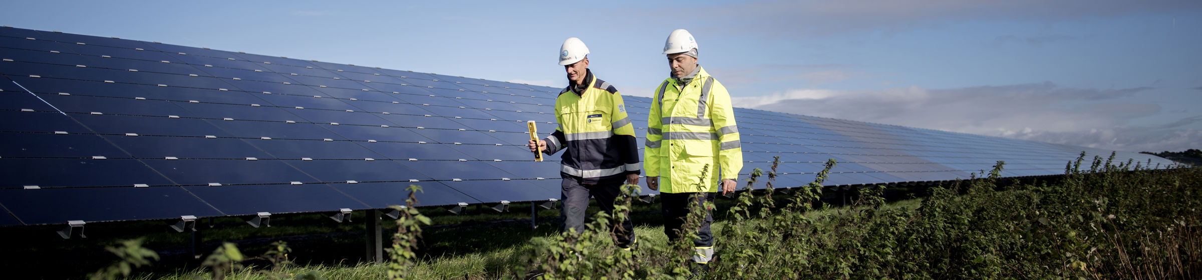 Zwei Mitarbeiter vor Solarpark