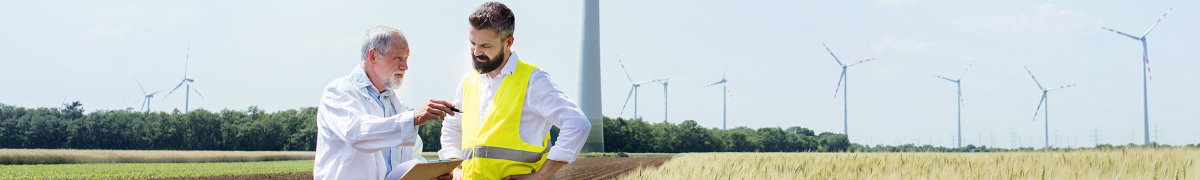 engineers standing on wind farm making notes