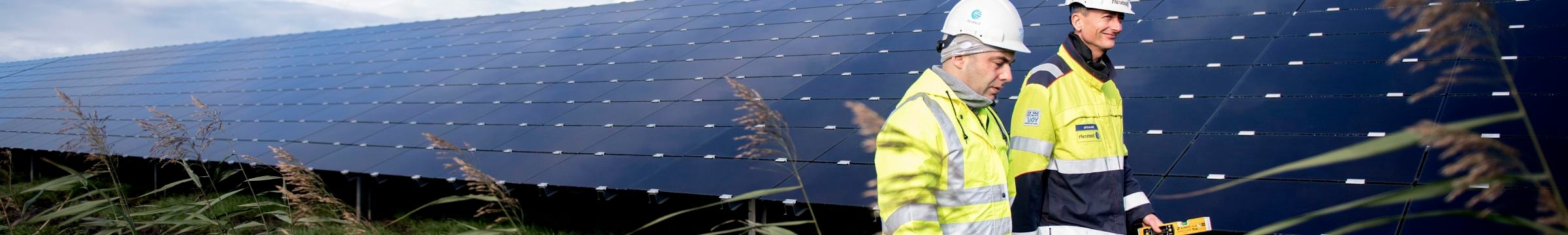 Zwei Mitarbeiter laufen im Solarpark Lange Runde herum