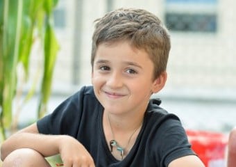 Junge sitzt und lächelt