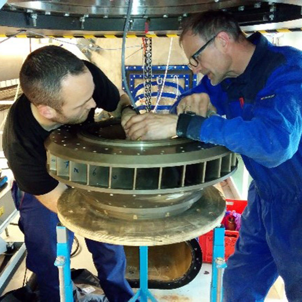 Zwei Männer begutachten Turbinenrad