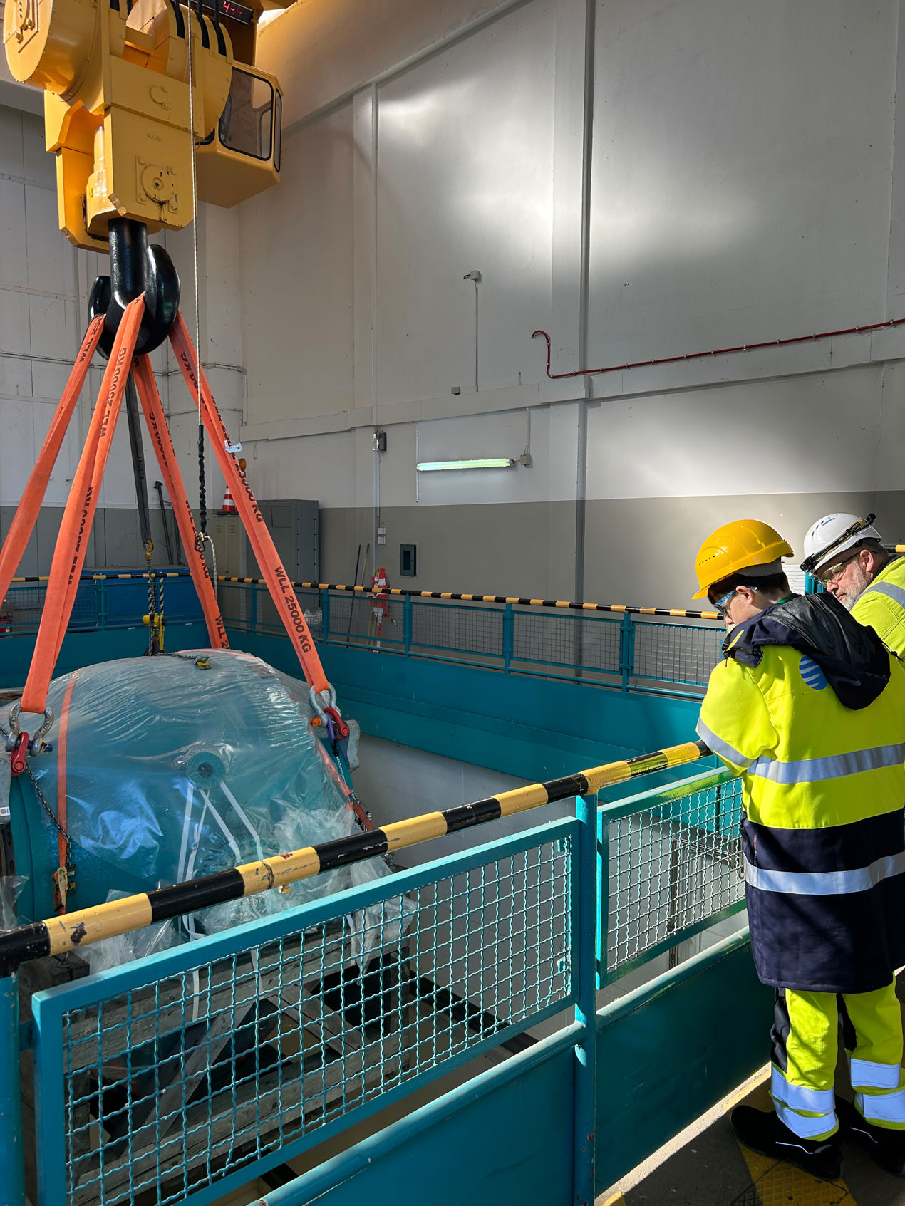 Henry schaut sich gemeinsam mit Mitarbeiter Oliver Burgsm&uuml;ller das Einlassen des reparierten und wieder angelieferten Kugelschiebers in die Maschinenhalle an.