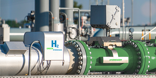Eine Pipeline für grünen Wasserstoff, im Hintergrund ein Industriegebiet
