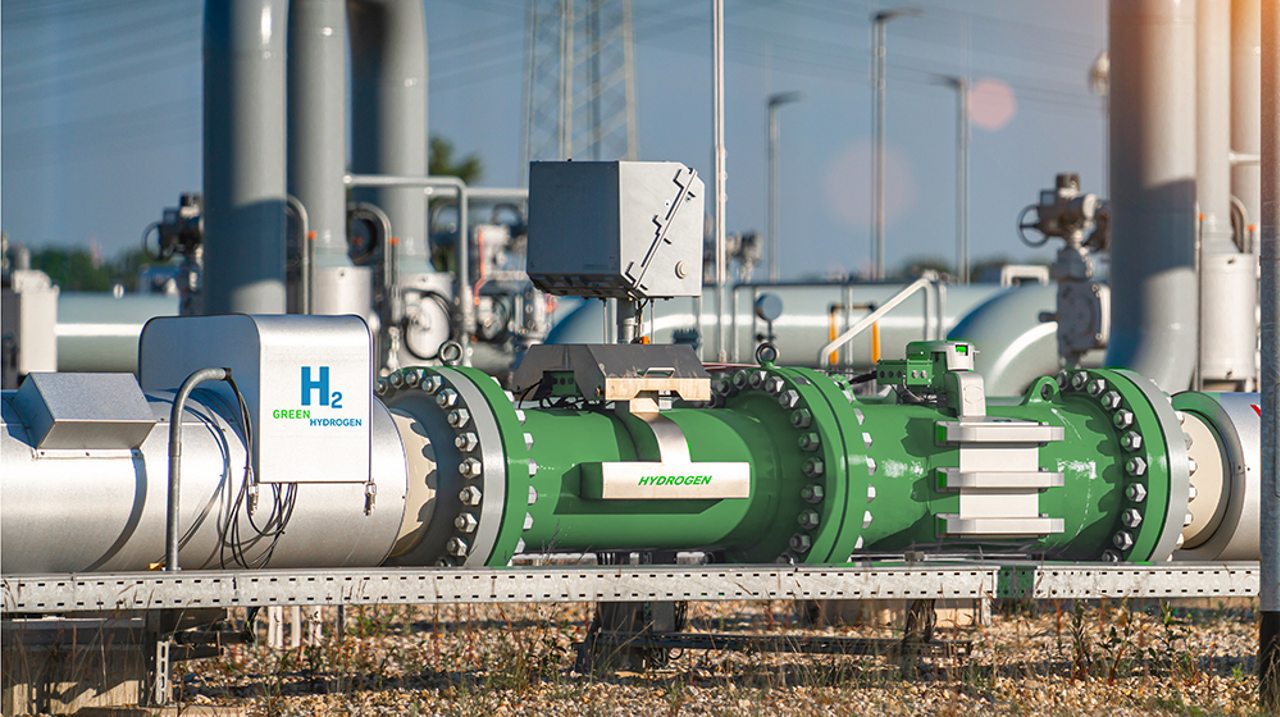Eine Pipeline für grünen Wasserstoff, im Hintergrund ein Industriegebiet
