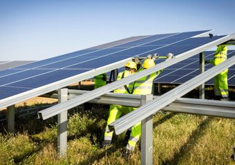 Zwei Monteure installieren ein Solarmodul auf dem Unteraufbau