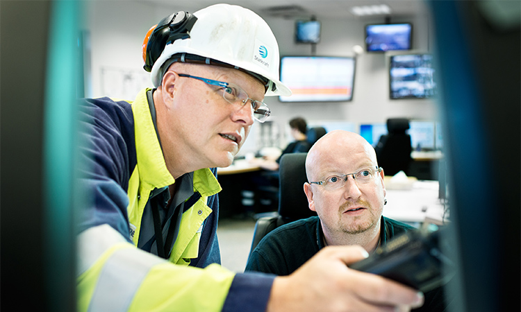 Zwei Männer analysieren etwas auf einem Bildschirm im zentralen Kontrollraum im Kraftwerk Knapsack