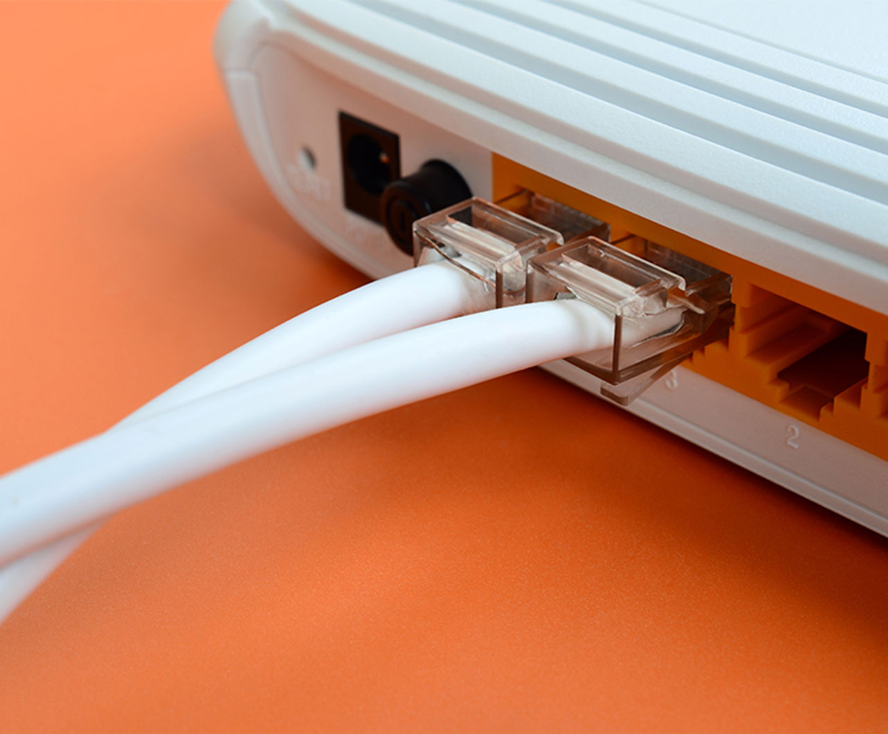 Das Bild zeigt einen Router mit eingesteckten Kabeln