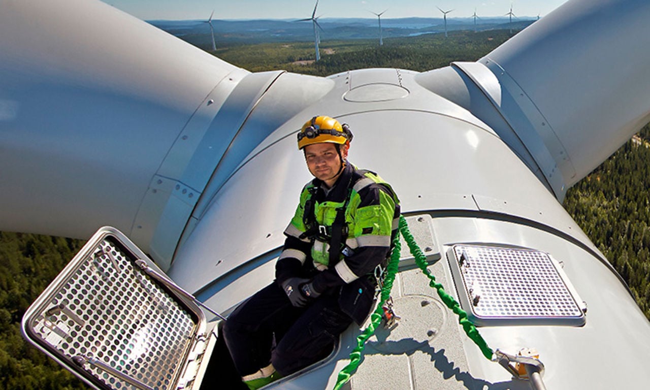 Arbeiter sitzt auf einer Windturbine